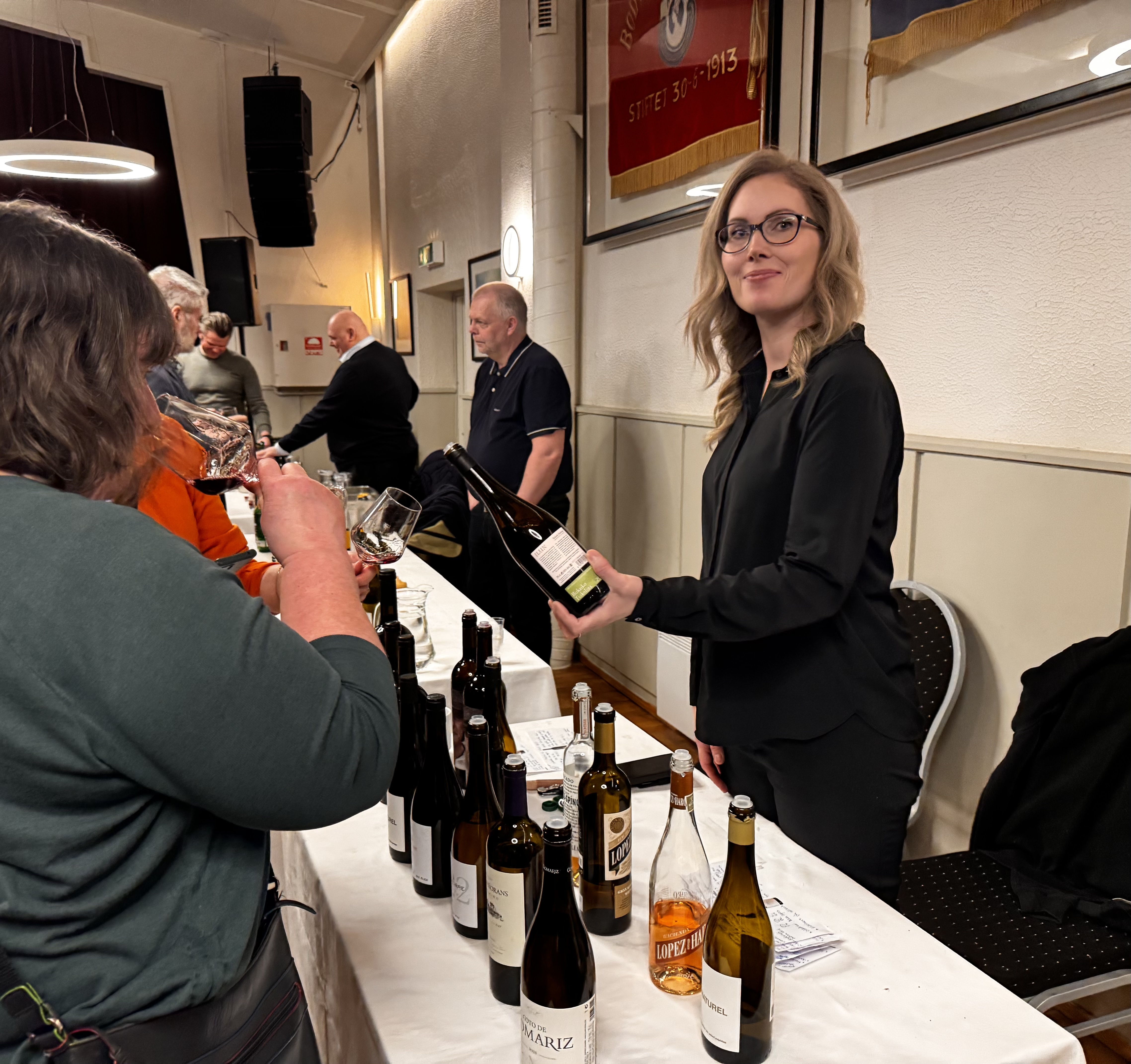 Vinsmaking på Folkets hus i Bodø våren 2025. Maria Brenden i JP Wine byr på smaksprøver til publikum. Foto: Privat.