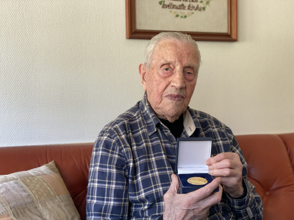 Odd Borlaug føler han har snakka seg ferdig om krigen, men viser fram ei av utmerkingane han har fått for innsatsen. Foto: Eli Strand / NPK.