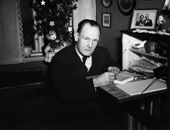 Johannes Sigfred Andersen også kalla «Gulosten» (1898 – 1970) var med i Kompani Linge under andre verdskrigen. Her signerer han boka om livet sitt, «Vi kommer oss» i 1947. Foto: TH. Skotaam / Aktuell / NTB / NPK
