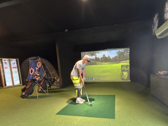 Carl Robert Brenden har vore ivrig skikøyrar i fleire år, og har endeleg fått seg ein ny hobby han kan drive med om sommaren, fortel han framfor golfsimulatoren. Foto: Heidi Molstad Andresen / NPK